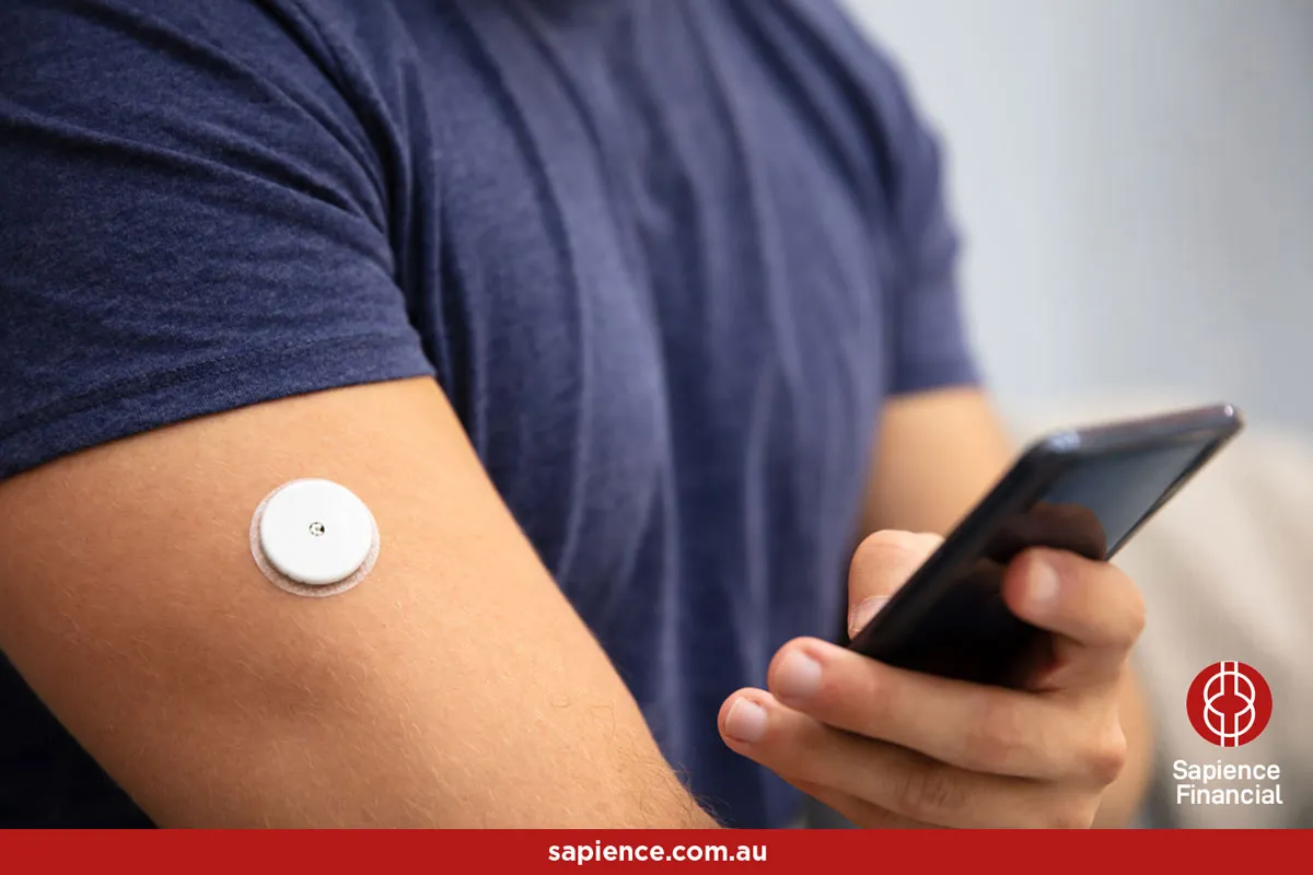 young man wearing an adhesive continuous glucose monitor (CGM) sensor to manage his insulin needs