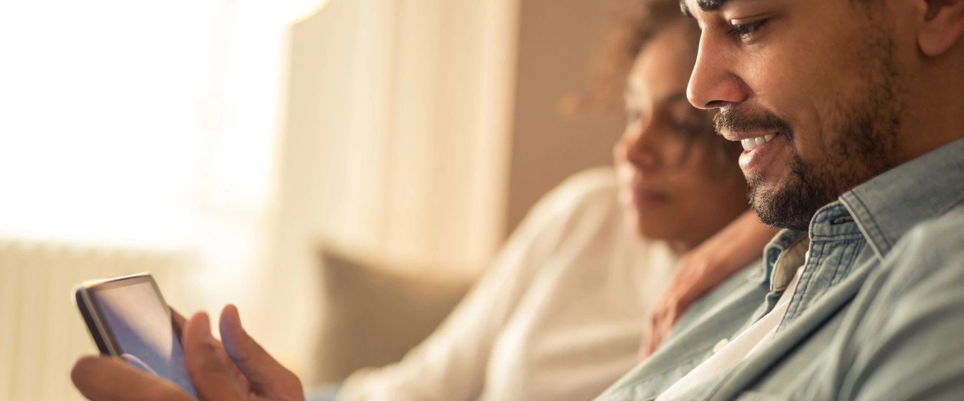 young couple making chnages to life insurance nominations from mobile device