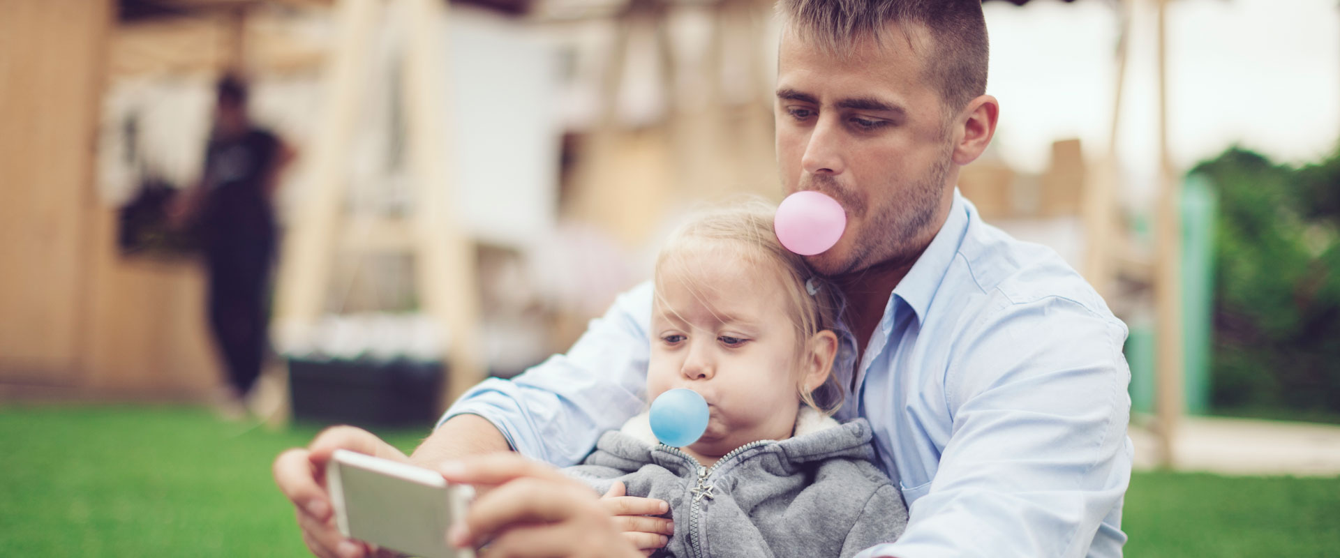 father and young daughter blowing bubblegum bubbles for selfie picture