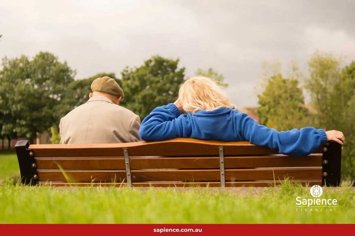 elderly man sitting on park bench with daughter