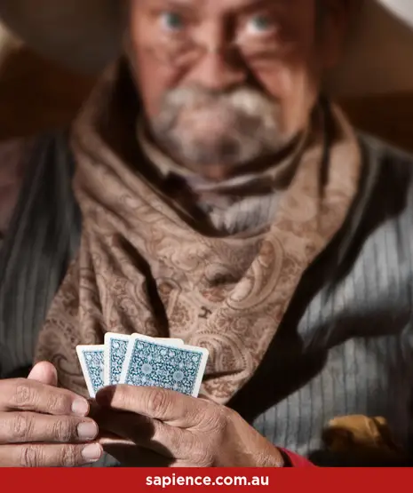 A time weathered looking cowboy playing poke in a wild west saloon