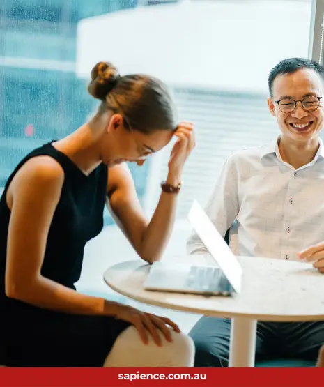 three business friends sitting at a table and laughing and enjoying the moment together