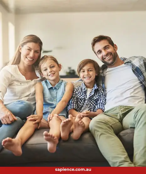 happy young blending family sitting on the couch