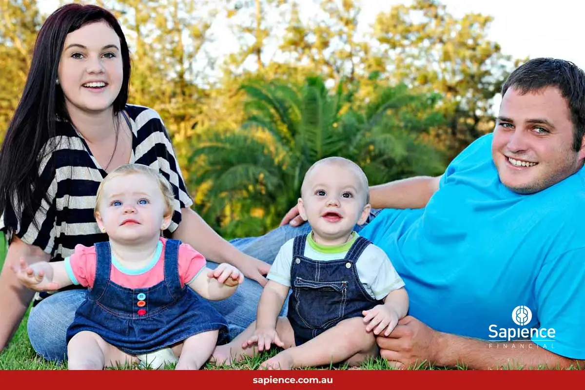 young family sitting on grass
